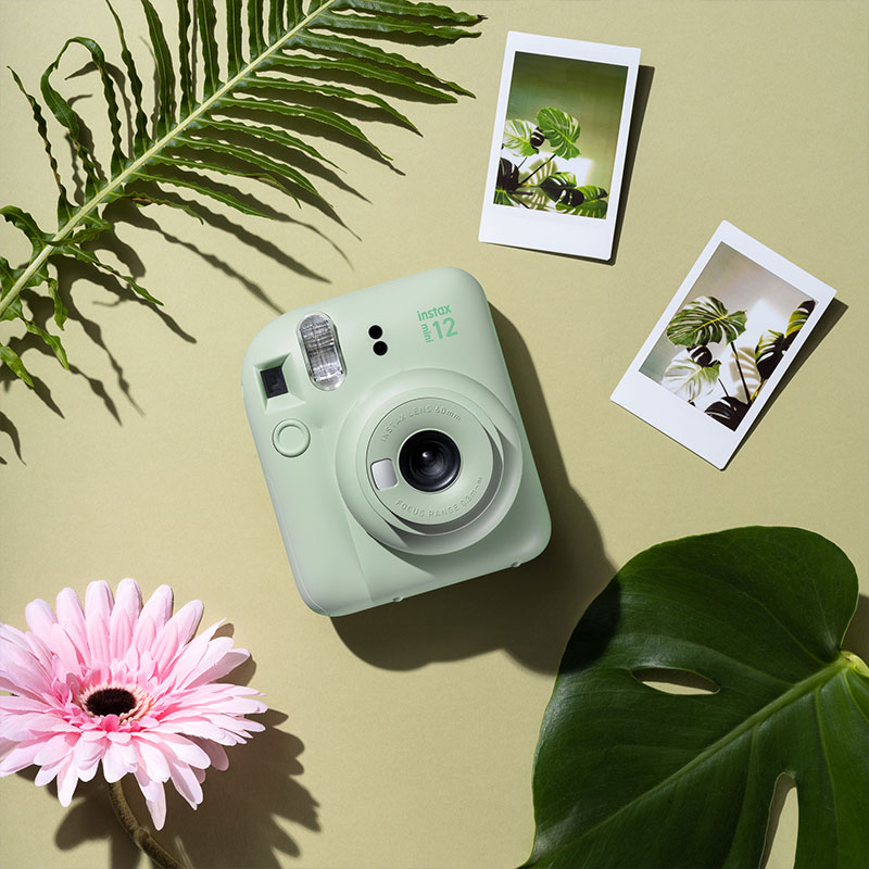 Instax Mini 12 camera held in hand showing compact, lightweight design