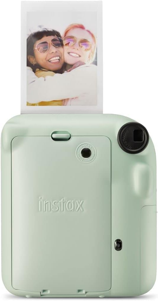 Instax Mini 12 instant camera printing a photo of two friends smiling